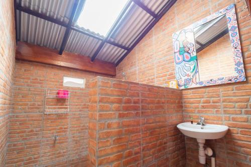 a bathroom with a sink and a brick wall at rumah kayu sulawesi antique in Bedugul