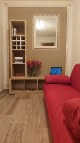 uma sala de estar com um sofá vermelho e um espelho em miniapp. a 2 km da Pedavena em Pedavena