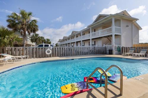 a swimming pool in front of a house at 2bd 2ba 1st floor condo WALK TO BEACH in Gulf Shores