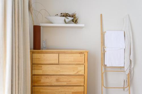 a room with a wooden dresser and a shelf at Ocean & Country Views, Spa, Pets Welcome, Fireplace - Your Ocean Oasis 10 minutes to Phillip Island in Kilcunda