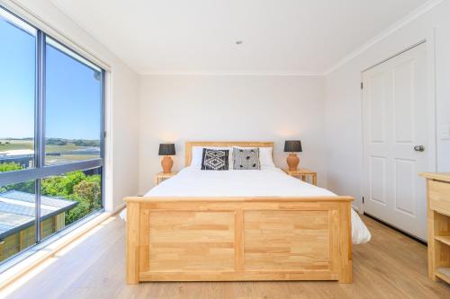 a bedroom with a bed and a large window at Ocean & Country Views, Spa, Pets Welcome, Fireplace - Your Ocean Oasis 10 minutes to Phillip Island in Kilcunda