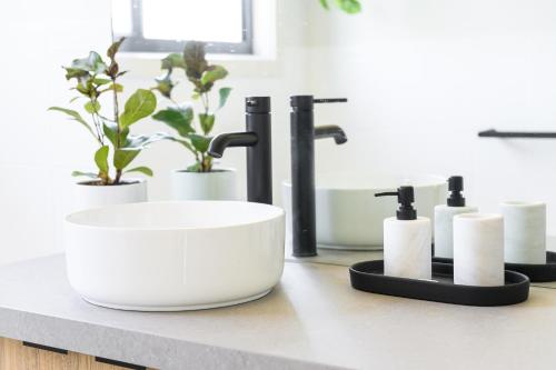 a bathroom counter with a sink and toiletries on it at Ocean & Country Views, Spa, Pets Welcome, Fireplace - Your Ocean Oasis 10 minutes to Phillip Island in Kilcunda