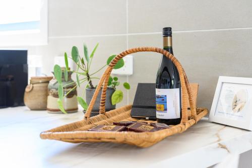 a basket with a bottle of wine on a counter at Ocean & Country Views, Spa, Pets Welcome, Fireplace - Your Ocean Oasis 10 minutes to Phillip Island in Kilcunda