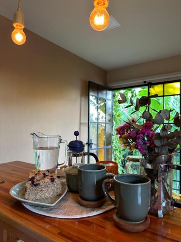 una mesa con dos tazas y un plato de comida en Tanah Loft - en Villa Mercedes