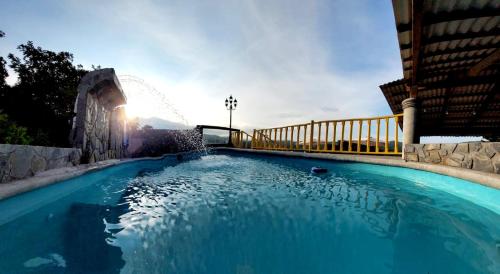 a large blue swimming pool next to a building at Hotel Posada San Agustin in Xilitla