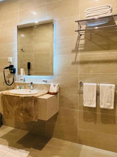 a bathroom with a sink and a mirror at Lolia Hotel فندق لوليا الفندقية in Raʼs Tannūrah