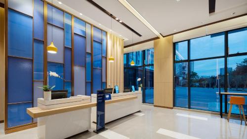 an office lobby with a reception desk and large windows at Holiday Inn Express Shunde Daliang, an IHG Hotel in Shunde
