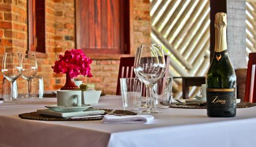 a table with a bottle of wine and glasses on it at Hotel & Pousada Tatajuba in Canoa Quebrada