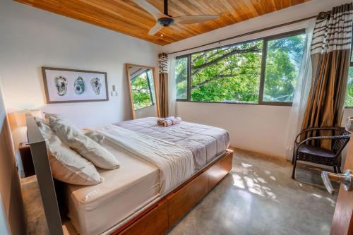 1 dormitorio con cama y ventana grande en Entire Nosara Tree House, en Nosara