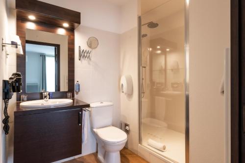 a bathroom with a toilet and a sink and a shower at Domaine de Cicé-Blossac, Resort Spa & Golf in Bruz