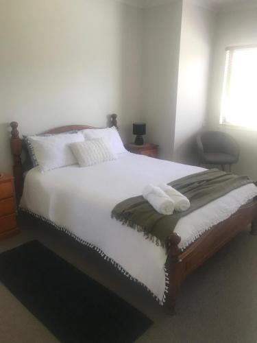 a bedroom with a bed with two towels on it at Water View Country Cottage in Yandina Creek