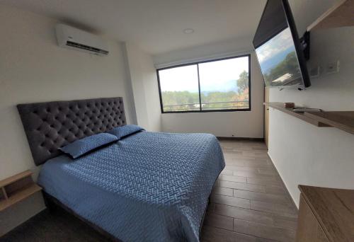 1 dormitorio con cama y ventana grande en Acogedora Cabaña en Sopetran en Otrabanda