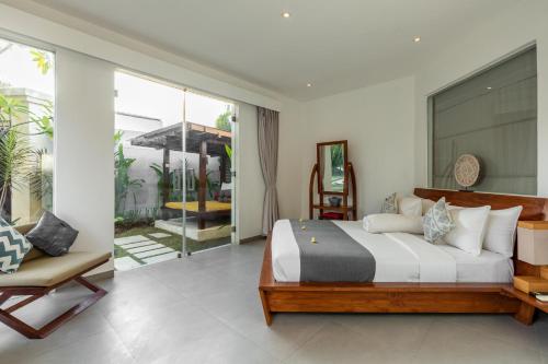 a bedroom with a large bed and a balcony at Villa Belle Seminyak by Bali Villas R Us in Seminyak