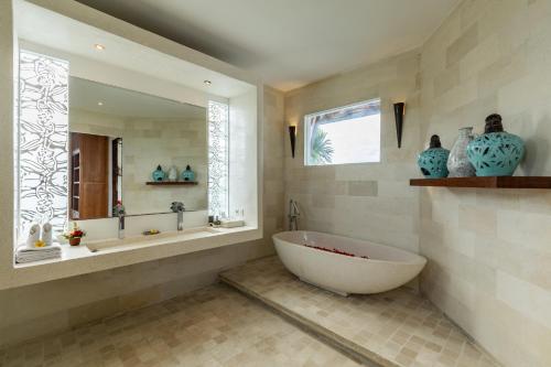 a bathroom with a tub and a sink and a window at Villa Belle Seminyak by Bali Villas R Us in Seminyak