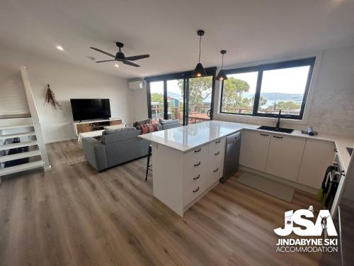 an open kitchen and living room with a large island at Casa Della Vita in Jindabyne