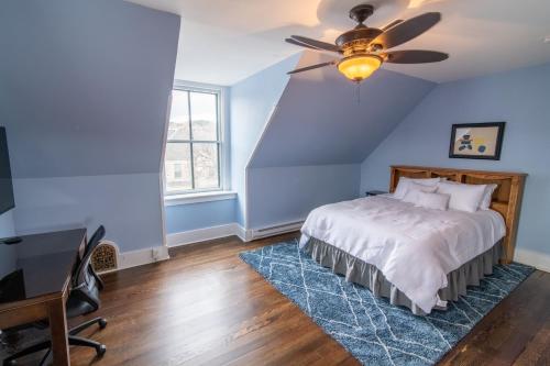 a blue bedroom with a bed and a ceiling fan at Pope House - Hist. Mansion - The Wild(e) Suite in Helena