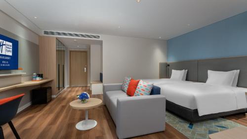 a hotel room with a bed and a couch at Holiday Inn Express Shunde Daliang by IHG in Shunde
