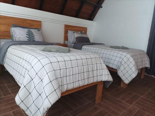 Dos camas sentadas en una habitación con en Villa HOMEY Lombok, en Kuta Lombok