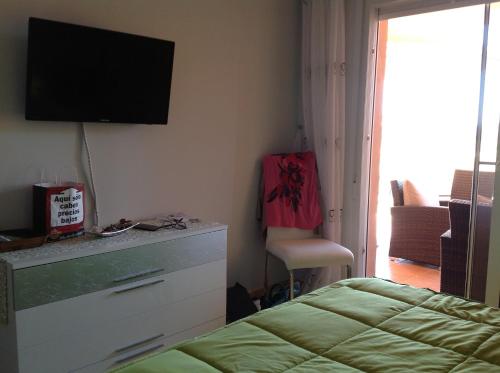 トレ・パチェコにあるLuxury appartment on golf resortのベッドルーム1室(ベッド1台、壁掛けテレビ付)