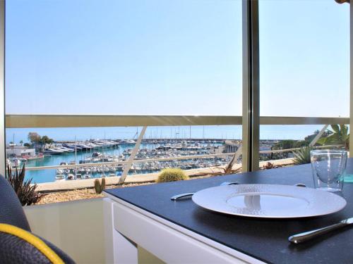 - une table avec une plaque et une vue sur le port dans l'établissement Superbe 3 Pièces avec Terrasse, Clim et Vue Mer à Villeneuve-Loubet - FR-1-252A-92, à Villeneuve-Loubet