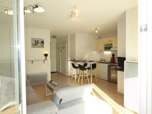 une cuisine et un salon avec un canapé et une table dans l'établissement Charmant T3 à Montauban-de-Luchon, 41m², véranda, jardin sud 58m², parking sécurisé - FR-1-313-219, à Montauban-de-Luchon