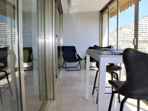 a dining room with black chairs and a table at Superbe 3 Pièces avec Terrasse, Clim et Vue Mer à Villeneuve-Loubet - FR-1-252A-92 in Villeneuve-Loubet