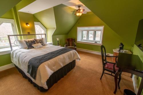 ein Schlafzimmer mit grünen Wänden und ein Bett in einem Zimmer in der Unterkunft Pope House - Hist. Mansion - The Green Suite in Helena