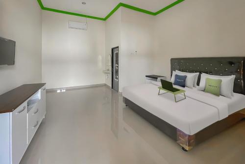a bedroom with a large bed with a green ceiling at Urbanview Hotel Tirtamaya Jaya Indah Indramayu by RedDoorz in Indramayu