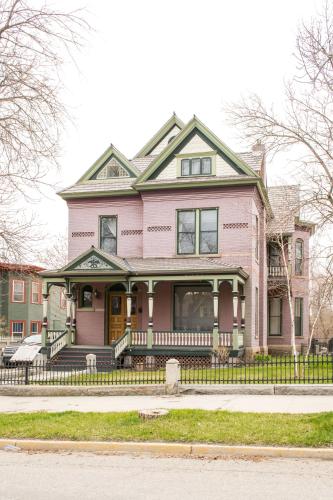 a pink house with a porch on a street at Pope House - Hist. Mansion - The Gold Rush Suite in Helena
