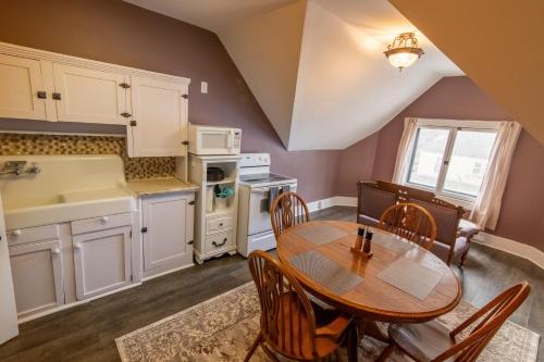 a kitchen with a table and chairs in a room at Pope House - Hist. Mansion - The Gold Rush Suite in Helena