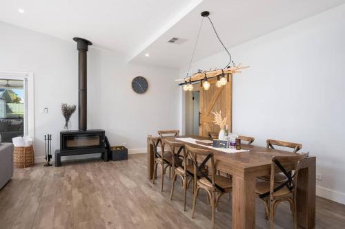 a dining room with a table and chairs and a fireplace at 'Austin' Mudgee in Mudgee