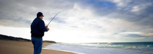 a man standing on the beach flying a kite at Ocean & Country Views, Spa, Pets Welcome, Fireplace - Your Ocean Oasis 10 minutes to Phillip Island in Kilcunda