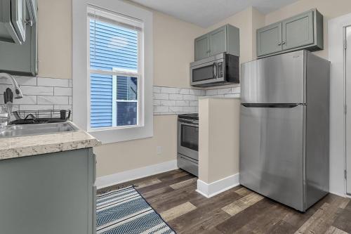 a kitchen with a stainless steel refrigerator and a window at Chic 2BR near DT, 8 min walk to Park&Conservatory in Columbus