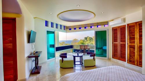 1 dormitorio con 1 cama, mesa y sillas en Luxury Waterfall Suite overlooks the impressive 60 feet high waterfall en Puerto Vallarta