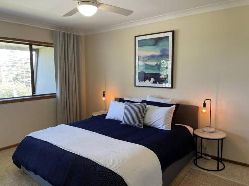 a bedroom with a blue and white bed and a window at Taranaki Penthouse - wonderful in Port Macquarie