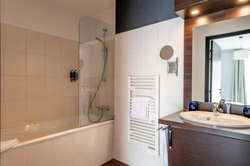 W łazience znajduje się umywalka, wanna i prysznic. w obiekcie Domaine de Cicé-Blossac, Resort Spa & Golf w mieście Bruz