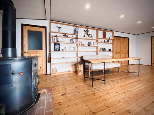 cocina con mesa y fogones en una habitación en Azumino Fukuro Guesthouse - Vacation STAY 27117v, en Azumino