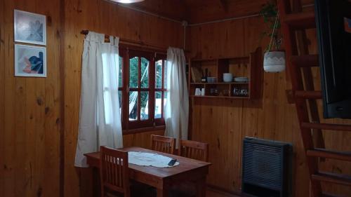 a dining room with a table and a window at Cabaña Aiken in Esquel