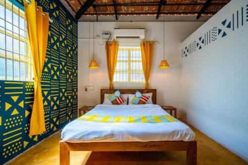 a bedroom with a bed with yellow and blue curtains at Luxury 6 BHK Villa with Private Swimming Pool in Old Goa