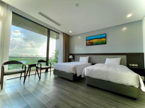 a bedroom with two beds and a large window at DIAMOND HOTEL VÂN ĐỒN in Cẩm Phả