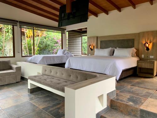 a bedroom with two beds and a couch at Hotel Delirio Campestre in Montenegro