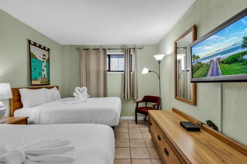 a hotel room with two beds and a flat screen tv at Spectacular Oceanview Condos in Myrtle Beach