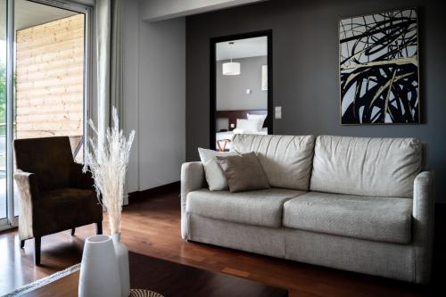 a living room with a couch and a chair at Domaine de Cicé-Blossac, Resort Spa & Golf in Bruz