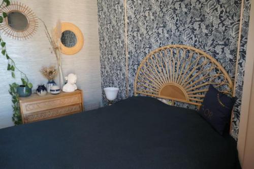 sypialnia z łóżkiem z drewnianym zagłówkiem w obiekcie Bel Appartement vue mer SAINT BREVIN LES PINS w mieście Saint-Brévin-les-Pins