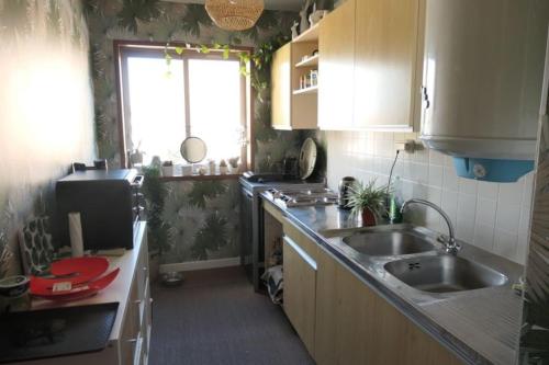 uma pequena cozinha com dois lavatórios e uma janela em Bel Appartement vue mer SAINT BREVIN LES PINS em Saint-Brévin-les-Pins