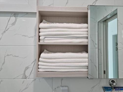 a stack of towels in a bathroom with a mirror at Tamnaneun Farm in Jeju