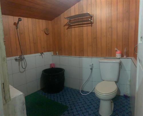 a bathroom with a toilet and a trash can at Villa Situ Citiwu Ciwidey in Ciwidey