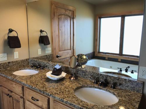 a bathroom with two sinks and a large tub at Pine Ridge Paradise in Red Lodge
