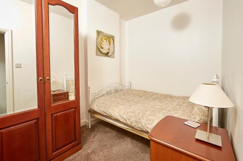 a bedroom with a bed and a desk and a mirror at ire House Eire House in Coventry