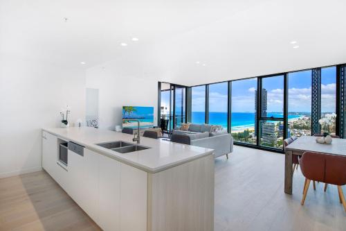 a kitchen and living room with a view of the ocean at Signature Broadbeach Ocean Views Apartment - CoastHM in Gold Coast